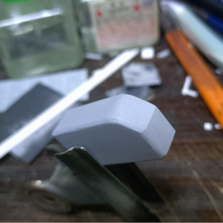 次に継ぎ目を綺麗にしたら今度は垂直なエッジ、アール、C面の角を必要に応じて整形します。このパーツはちょうど3種類の角があるので分かりやすいかな?エッジを立たせる場合は必ずカナヤスリを使って綺麗に均等に整形します。これが中々難しい(笑)角を削ると言うことは張り合わせたプラ板にそれなりの厚みが無いと穴が空いてしまいますので、箱組みの際は1mm以上のプラ板を使いましょう。パーツが大き目なら強度的にも中にスペーサーを接着して補強するのも大事です。1mm以上のプラ板を使えば多少面の角度が斜めったりしても削って修正も可能なので慌てず騒がす(笑)写真ではまだ甘いのでここから仕上げの整形で綺麗にします。仕上げのヤスリ掛けは真っ直ぐ綺麗にヤスる必要があるのでこればっかりは慣れと経験が必要ですねぇ~線が曲がってしまうと出来栄えにかなりのダメージになるのでここは細心の注意を払う工程ですねぇ~