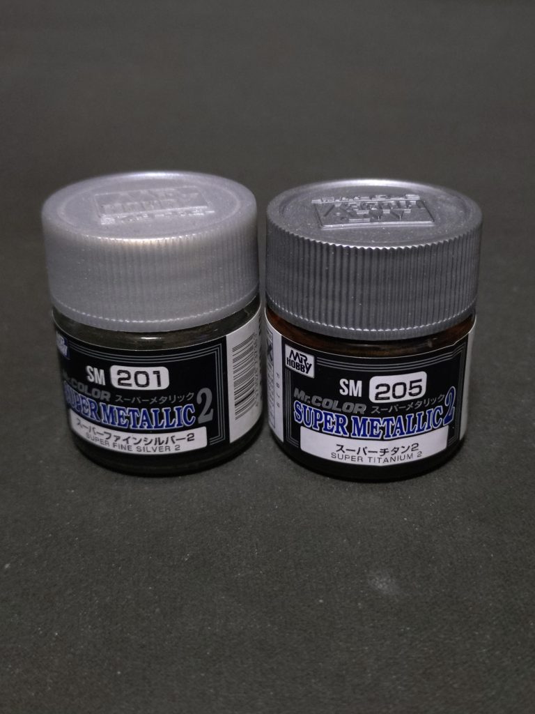 関節周りはもっぱらクレオスのスーパーメタリックシリーズを愛用してます。黒で下地塗装後に吹いてクリアーコートしてます。(クリアーコートすると金属粒子が流されてほぼグレーになってしまうカラーもあるので要注意)関節をメタリックに塗る様になったきっかけは破損が怖く可動部分にエナメル塗料のスミ入れをしたくないってのが理由ですね。ウェザリングしたくないのも破損が怖いのが理由(笑)ザクver.2の頃のMGのフレームなんかはまだまだ塗装しづらいABS樹脂が主流で塗装方法を間違えるとラッカーやエナメル塗料の浸透ですぐに割れてしまいます😭ラッカーで塗装の場合は最初に乾燥が早い砂吹きをして膜をある程度作ってしまってから塗装すればだいたい大丈夫だけれども、エナメルはどんなに対策してもヤバいので………😭チタン合金で出来てるMSが多いので装甲板以外は地金の色でも違和感無いかな?なんて思ってます。
