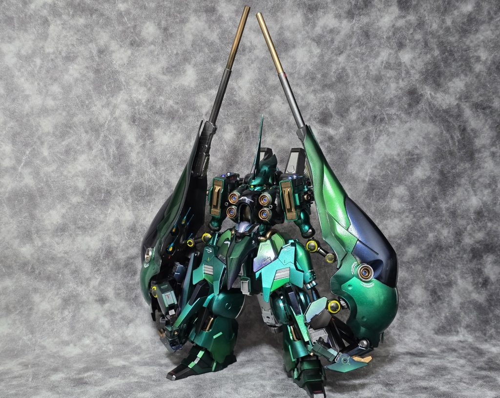 型式番号　NZ-666RA機体名　クシャトリヤ・リーゼンアーム​本機は、パラオ攻略戦およびラプラスの箱を巡る戦いで大破した「NZ-666 クシャトリヤ」を、ビスト財団の本拠地メガラニカにて回収、新しいコンセプトの元再設計されたリファイン機である。パイロットは引き続き、奇跡的に生還したマリーダ・クルスが務める。​従来のバインダーを「巨大な腕（リーゼンアーム）」へと作り変えることで、格闘性能と火力を大幅に引き上げている。機動力こそ若干低下しているものの、その分を装甲と全レンジ対応の武装で補った、「対MS・対艦戦闘特化型」の重モビルスーツである。