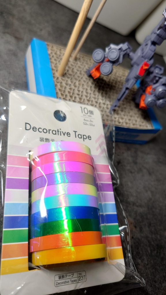 ツインアイやセンサー類等は付属シールの余白部分のシルバーを同じ形に切出し、上からハイキューパーツさんのオーロラブルーシールまたは百均のホログラム装飾テープを重ね貼りしています。