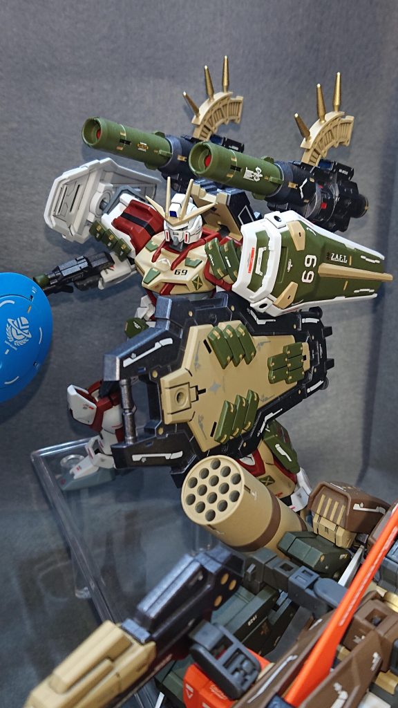 機体No.69：ビッグシールドストライクhttps://gumpla.jp/eg/2377296本機体は、防御面に重きを置き追加装甲や各種シールドで固めた拠点防衛型のストライクとなっています💡これまで作ってきたストライク改造の中でここまで防御面を意識して制作したことが無かったので、とても新鮮な気持ちで制作に取り組めましたｗ守りのメイン武装は、30MMのカスタマイズウェポンズ(ヘビーウェポン1)に収録されている大型シールドに装甲を少し追加したモノとなっており、シールドのカラーリングを3色にすることで積層式のシールド感を強く出すように工夫してみました！他にもシールド裏には、自立用の脚が付いておりシールドを手放しての精密射撃が可能となっていたり、敵に距離を詰められたり残弾が無くなった場合の最終手段としてビームサーベルがマウントされています自分でもかなり良いシールドに仕上がったと満足しています✨攻撃手段としては防御力を伸ばした為、機動力がイマイチになってしまったので後方からの砲撃による火力支援がメインになりますオリジナルのバックパックに大型のキャノンを2門装備させた高火力仕様にできたのはとても良かったのですが、今振り返ってみると砲撃機にしてはセンサー要素が少し足りていないように感じています💦最近は100均の“デコレーションシール”を使用したディテールアップを覚えたので、この反省を活かすためにも砲撃機には積極的にセンサーを増やすようなディテールアップを入れていきたいと考えています💡ｗ機体全体としては自分でも驚くほど良い仕上がりになりましたし、閲覧数は自分が作ったストライク達の中でも珍しく1万を超えました！いいねの数も今までトップだった“フォビドゥンストライク”を抜いて1番になるほどに、皆様から高い評価をいただけてホントに嬉しい結果となっていますｗ✨