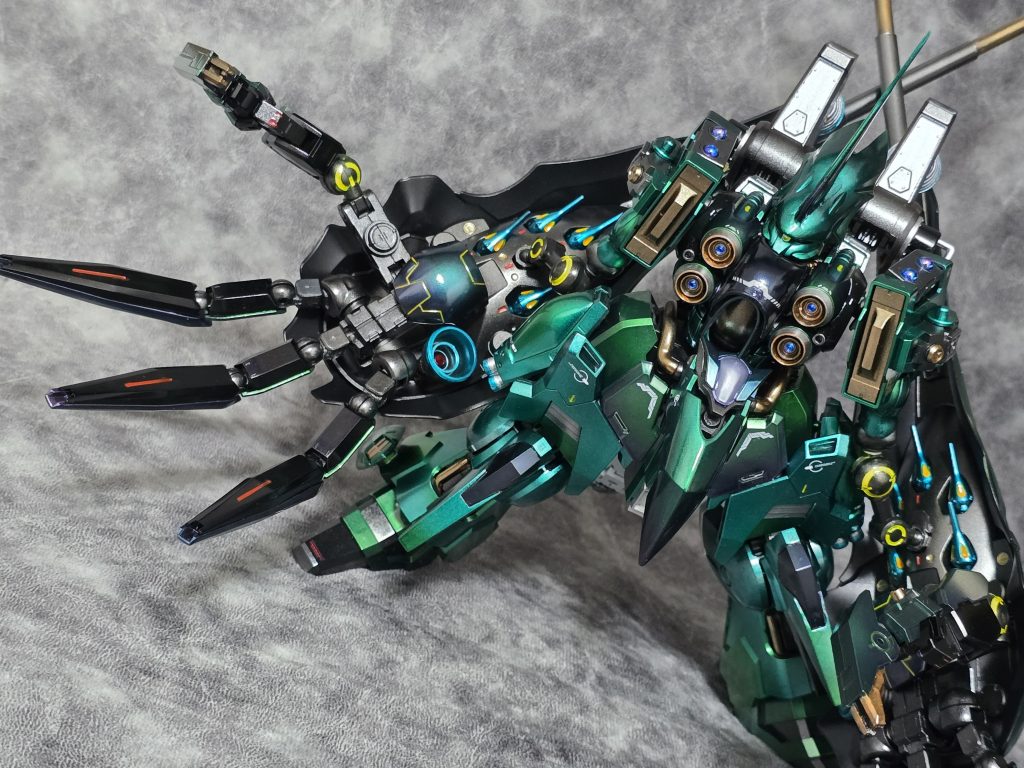 全領域制圧複合重兵装『ラークシャス』リーゼンアームの由来となるサイドバインダーから腕部として改修された兵装。元のバインダーにあったＩフィールド・ジェネレーター、収束・拡散の選択が可能な２門のメガ粒子砲はそのまま、指に相当するビーム砲が３門、ビーム刃を形成するクロー、長々射程のロングレンジビームキャノンを追加、ファンネルの搭載数はそれぞれ５機と減少しているが、近、中、遠、超長距離まで対応できる兵装に仕上がっている。いつからか、クシャトリヤのバインダーが腕甲にしか見えなくなってしまい、いつか作りたいと考えていました。指の部分はジャイオーンと30MMのジャンクを組み合わせています。