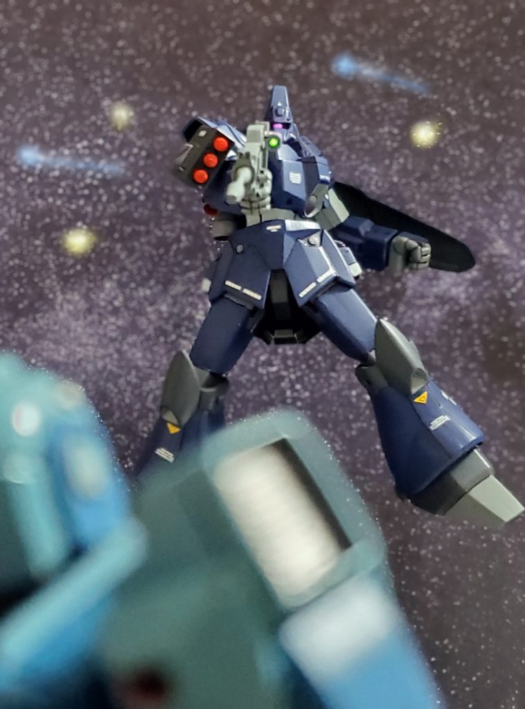 レナはすぐさま、ビームライフルを放った相手の方向に姿勢制御で機体を向ける。そこには銃口を向けたまま次弾を放たず、まるでレナがこちらを向くのを待っていたかのように構え佇むガルバルディβの姿があった…。そしてなんと、そのガルバルディから傭兵の専用回線で通信が飛び込んでくる‼️『いよぉ…メイベル、久しぶりだなぁ…。ずいぶんと、けったいな機体に乗ってるじゃねぇか?』なんと❗その声の主は同業者のフィリップ・ヒューズであった‼️彼はレナと同じ傭兵斡旋組織に登録している傭兵。これまでも依頼要請により、組んで仕事をこなした事もあるよく知る人物であった。『あら。こんなところで会うなんて奇遇ね🎵』フィリップ・ヒューズの言葉に、内心を悟られぬよう軽い返答を返すメイベル・レナ。だが心の中で、彼の実力を知る彼女は厄介な相手が敵に回ったと焦りを感じるのであった……💫以上、私の妄想イメージによるネモ・シュタルクとメイベル・レナの活躍ぶりでした~🙌🎶