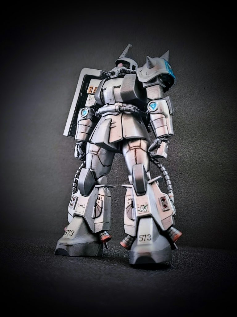 前面カット。主な改造箇所は以下の通り。頭部：形状調整。モノアイをビルダーズパーツに変更。胸部：左右の幅拡大。左肩：スリット（金色）部分のディテールをより細かく（百均の結束バンドを加工）太もも：エポパテでボリュームアップ。膝：HGUCザクⅠの膝パーツを加工して使用。足首：HGUCザクⅠの足首を加工して使用。手：握り手、平手はビルダーズパーツとキットの手の甲を組み合わせ（マシンガンの手はキットのままです）武器類：スコープ類をビルダーズパーツに変更（バズーカは写真にないですが、一応マシンガン同様に加工しています）