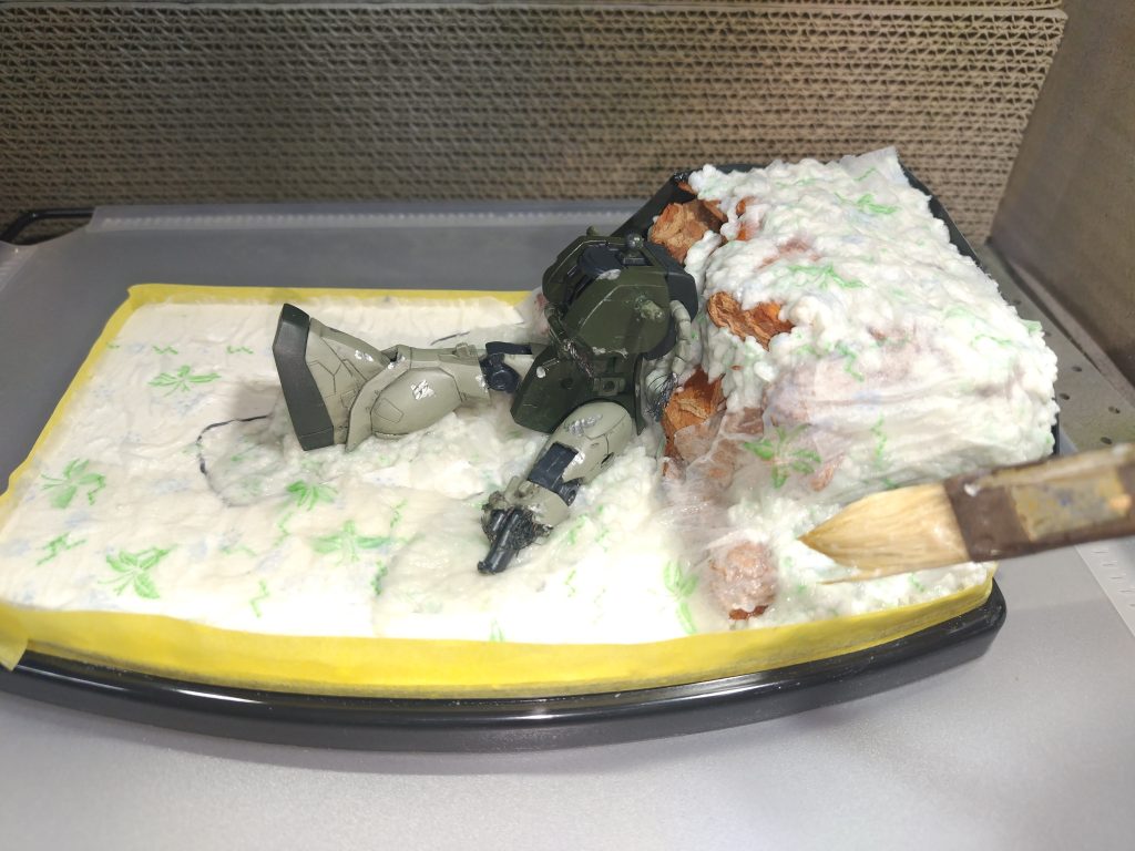 大体の盛り付けが済んだら、まんべんなくトイレットペーパーを敷いて、上から水溶きの木工用のボンドを染み込ませます。しわが出来たり破けても気にしません。