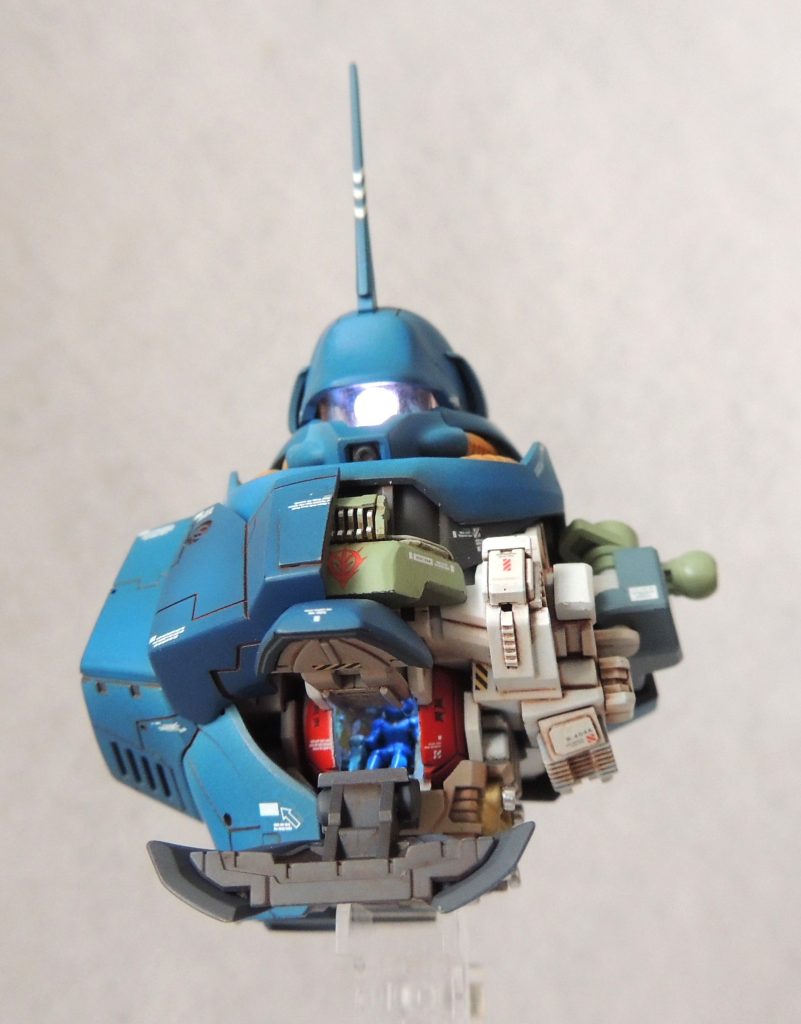 ■電飾　頭部カメラ、コクピット内の天井に電飾を仕込みました。使用した商品は、「ビット・トレード・ワン MMGL-W2-WH ホワイト [磁気スイッチ付LEDモジュール2灯]」であり、２か所を同時で光らせることができます。磁石をボタン電池ボックスに近づけることにより、簡単にオン・オフの操作をおこなうことができ、点灯パターンは「①点灯→②高速点滅→③ゆっくりとした点滅→④消灯」の順に切り替わります。ボタン電池(CR927／3v)ボックス兼スイッチは右胸のコクピットハッチ裏に設置しました。　上記商品の「ゆっくりとした明滅」の点灯パターンのおかげで、「モノアイカメラが”グポォン”と発光＆フワッと消灯」が簡単に再現できました。■頭部　頭部の形状は設定画や劇中イメージを良く再現しているため、モノアイの電飾のみ行いました。形状モノアイカメラに白色LED１基を仕込み、レンズ部分にHアイズを使用しました。「ゆっくりとした明滅」の点灯パターンのおかげで、モノアイカメラが”グポォン”と発光し、フワッと消灯します。