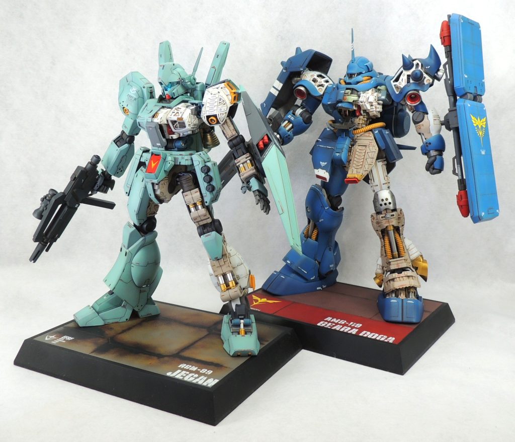 劇中で交戦したケーラのジェガンとレズンのギラ・ドーガを並べてみました。直線的で角ばったシルエットをもつジェガンに対し、曲線主体のフォルムが印象的なギラ・ドーガが好対照をなしています。 戦争では互いの正義のもと、敵味方に分かれて命のやり取りを行いますが、それが同一企業のMSどうしで行われるという皮肉が込められているように感じます…。