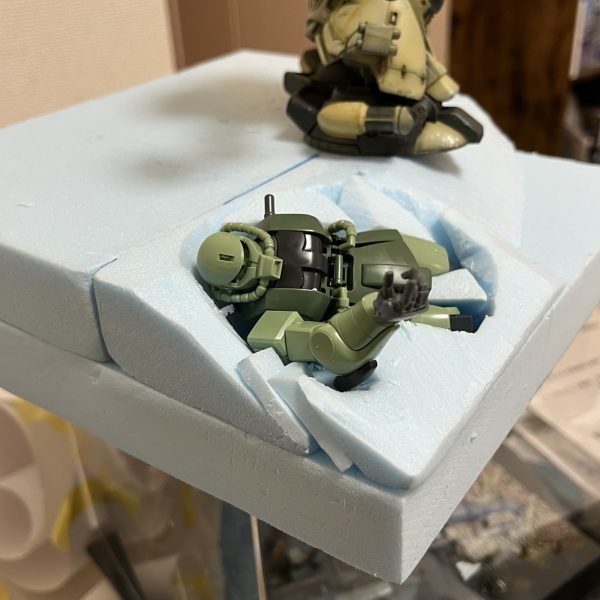 スタイロフォームを切り出してレイアウトの確認です。ただの砂漠では芸が無いと思い、朽ち果てて砂に埋もれたザクを配置する事にしました。61式とワッパ目当てで購入した「イグルー重力戦線キット」…その中で行き場を完全に失っていたザクに活躍の場がようやく出来ました😅一年戦争時に大破放棄され数年経過している設定です。「砂原や…兵（つわもの）どもが夢の後…」って感じでダグラム並みに朽ちてもらおうと思います。ドムの背後は砂煙の為にスペースを空けています。皆さんのアドバイスでドラッグストアにて自然素材の綿を入手できました。ありがとうございました😊（6枚目）