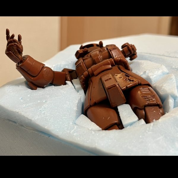 ザクと掘り込みの隙間をスタイロフォームの切れ端で埋めました。切れ端の隙間に木工ボンドを流し込んだら、その上からいよいよ壁補修材を塗り込みベースの下地を作って行きます。（3枚目）