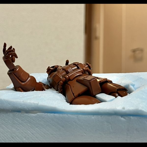 ザクと掘り込みの隙間をスタイロフォームの切れ端で埋めました。切れ端の隙間に木工ボンドを流し込んだら、その上からいよいよ壁補修材を塗り込みベースの下地を作って行きます。（7枚目）