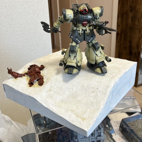 ジオラマベースの作成です。側面の露出したスタイロフォームに0.3ミリのプラ板で化粧回を施します。スタイロフォームに木工ボンドを塗ったらその上に幅だけ合わせた高さは大雑把な長方形にカットしたプラ板を貼り付けます（2枚目）。乾燥後にハサミでベースの地面ラインに合わせて切り取ります（3〜5枚目）。使用したハサミはキッチンハサミと爪切りハサミ（7枚目）。その後、プラ板とスタイロの隙間に再度パウダーを混入した石膏を塗り込み、乾燥によりヒビが入った地面表面にも同じくパウダーを混入した石膏を指先で塗り込みます。私のジオラマ作りのいつもの作り方になります。（3枚目）