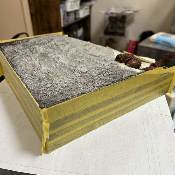 ジオラマの化粧回しが終わり、その上からマスキングテープを貼ったら地面とザクの塗装です。（3枚目）