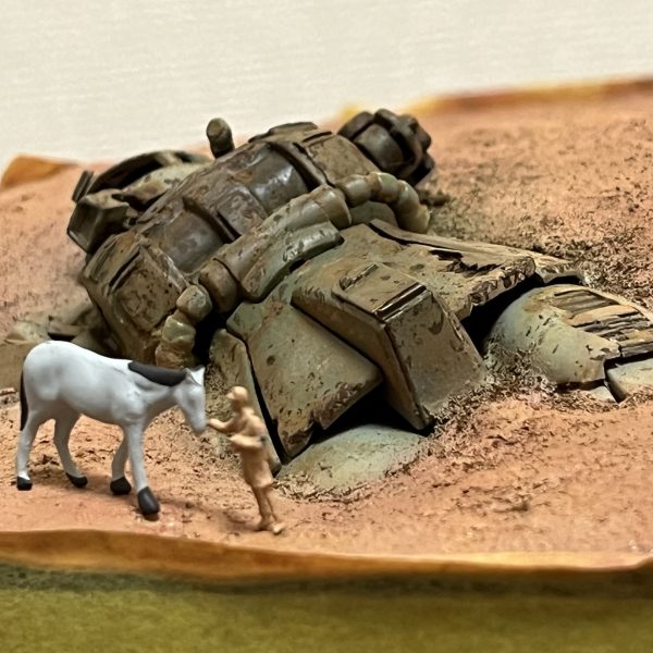 良い感じに朽ちてくれました。ジオラマ作ってて楽しいと思える瞬間ですね。ここまでのダメージ表現はジオラマを前提にしないと作品としてはなかなか成り立たないと思います。ダメージ痕の加工や表現にもこだわってみましたが如何ですか?「バラトン湖の戦い」っていう戦場写真集を持ってまして、ただただ「ソ連に撃破されたドイツ軍戦車」の写真が累々と掲載されているといった内容なんですが😅戦車のダメージ痕やクラッシュ姿が非常に参考になります。太もも辺りはドアンザクを参考にしてますけどね…😅さて、いよいよ次は巻き上がる砂煙の制作です。あとラクダも…😭(6枚目)