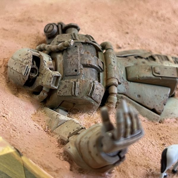 地面の色を手直ししてザクの周りと馴染ませました。フィギュアはサイズ感や臨場感を出すには、やはり良いアクセントです。ここはやはりくどいですがラクダですね。煽り気味のアングルが一番カッコいいのですがスカートの裏が見えてしまうのでバーニアを取り付けた方が良さそうです。（6枚目）