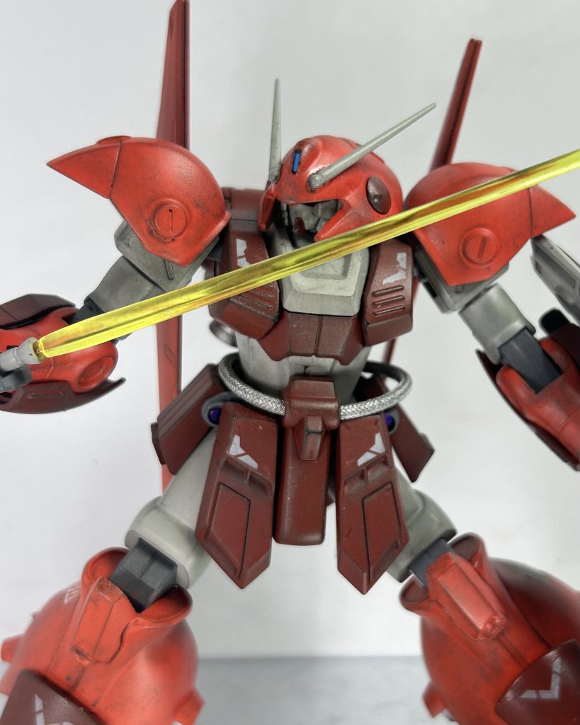 その光刃はマラサイに届く事は無かった。いつ抜いたのか、大型ビームサーベルによって防がれていた。「ヤツの目は潰したはずだ！」そう、バルカンの一撃でマラサイのカメラアイを破壊した。『甘いんだよ』未だに銃煙上がるマラサイのシルエットからの一撃。咄嗟に防ぐ事が出来たが…グスタフカールを後方に飛ばす。相手のカメラアイは潰した。であれば後は射撃戦に徹すれば、弄せず勝てるだろう。「負け惜しみを…！」シルエットから双眸が浮かび上がる。ツインアイ？一瞬突拍子のなさに操作が止まる。その隙を狙ってグレネードの連撃。すんでのところでシールドでガード出来たものの、不可解だ。頭部カメラにダメージを与えたにしては狙いが良すぎるのだ。ようやく煙が消える。「ーーな、ガ、ガンダム&nbsp;…！？」そう、剥がれ落ちるフェイスパーツの下から現れたのはガンダムフェイス。子憎たらしい通信が入る。『その顔が見たかったんだよ』それだけの為に？何故か妙に腹が立ってきた。「だからって性能は変わんねぇだろ！」冷静じゃなかった。フットペダルを踏み込み、斬りかかろうとしていた。気がついた時には既に行動をしていたのだ。『そりゃそうだ』マラサイ、いや、ガンダムのカメラアイに光が灯ると、フッと画面から消える。驚く前に、鈍い音と共にビームサーベルを持つ手がはね上げられていた。画面にはクルリと現れるガンダム&nbsp;。そうか、腕を狙って蹴り上げられたのか。『…ちぇ、そう簡単に上手くいかないか…』そう悟った時にはもう遅かった。ビーム光が画面いっぱいに表示され…続いて敗北表示。またもや負けた、一体何がダメだったのか。俺はまた頭を抱えた。