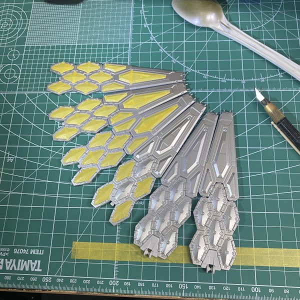 万博の翼。塗り分けできた、クリアまで吹いて、スミ入れまでした…投げ出しそうになったけど頑張りました💪後で拭き取ろう…デカール探しに行こうかな、赤色で小さなアクセントくらいでいいかな…🤔なんか繋ぎ目っぽいところ(画像赤丸)に緑センサー的なアクセントあっても良いんかなって思ったけど、青竹色でチップ作るのだるいから、手頃なものないかな…🤔(30mmのマテリアルシールってちょっと厚みあるのよね…ハセガワのフェニッシングペーパー？かな？？)…ところで作業台が汚いなwww（2枚目）