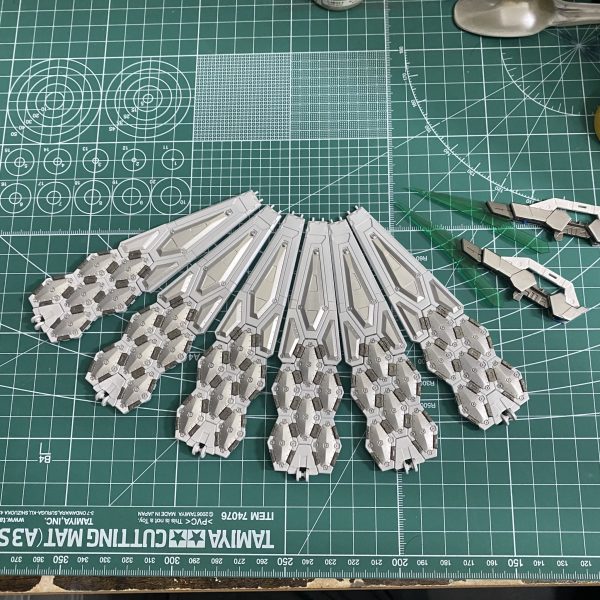 万博の翼。塗り分けできた、クリアまで吹いて、スミ入れまでした…投げ出しそうになったけど頑張りました💪後で拭き取ろう…デカール探しに行こうかな、赤色で小さなアクセントくらいでいいかな…🤔なんか繋ぎ目っぽいところ(画像赤丸)に緑センサー的なアクセントあっても良いんかなって思ったけど、青竹色でチップ作るのだるいから、手頃なものないかな…🤔(30mmのマテリアルシールってちょっと厚みあるのよね…ハセガワのフェニッシングペーパー？かな？？)…ところで作業台が汚いなwww（3枚目）