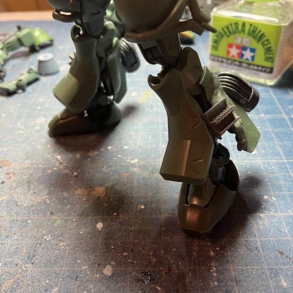 ザク三段活用、ガンダム共通一次に出るから忘れないように　 &nbsp;(*・ω・)／&nbsp;はい、GQザク進捗٩( 'ω' )و足廻り終わりましたキットの脛アーマーをひっくり返したら、あら不思議　笑足首周りにボリュームが出て良い感じに(zaku-kao2)ふくらはぎにはFZのスネアーマーを付けてジャンクやらディテールアップをつけて、それらしく？その代わりにガスタンク裏のバーニヤーはオミットして、スッキリ(zaku-kao6)コレで、やっと塗装に入っていけますカラーはノーマルザクⅡで行こうかと考えてます☺️（2枚目）