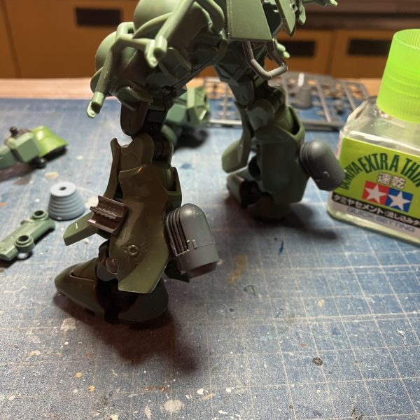 ザク三段活用、ガンダム共通一次に出るから忘れないように　 &nbsp;(*・ω・)／&nbsp;はい、GQザク進捗٩( 'ω' )و足廻り終わりましたキットの脛アーマーをひっくり返したら、あら不思議　笑足首周りにボリュームが出て良い感じに(zaku-kao2)ふくらはぎにはFZのスネアーマーを付けてジャンクやらディテールアップをつけて、それらしく？その代わりにガスタンク裏のバーニヤーはオミットして、スッキリ(zaku-kao6)コレで、やっと塗装に入っていけますカラーはノーマルザクⅡで行こうかと考えてます☺️（3枚目）