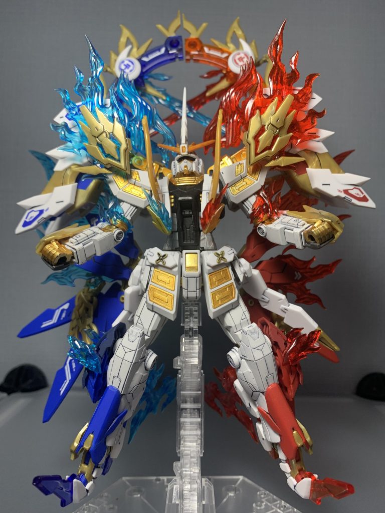 ◆第二段階:全開放状態(Awakening)封印を完全解除。藍と赫の聖光が融合臨界を迎え、KIRINは“聖獣そのもの”へと変貌する。背後の皇環が超励起し、空間を歪ませるほどの神圧を放つ。・開放武装:聖光双釵「藍月」・「赫月」皇鎧聖装状態において顕現する対神近接武装。藍(静)と赫(動)の聖光を結晶化させた一対の神釵。刃ではなく“概念を穿つ釵”。触れた装甲ではなく、存在そのものへ干渉する。