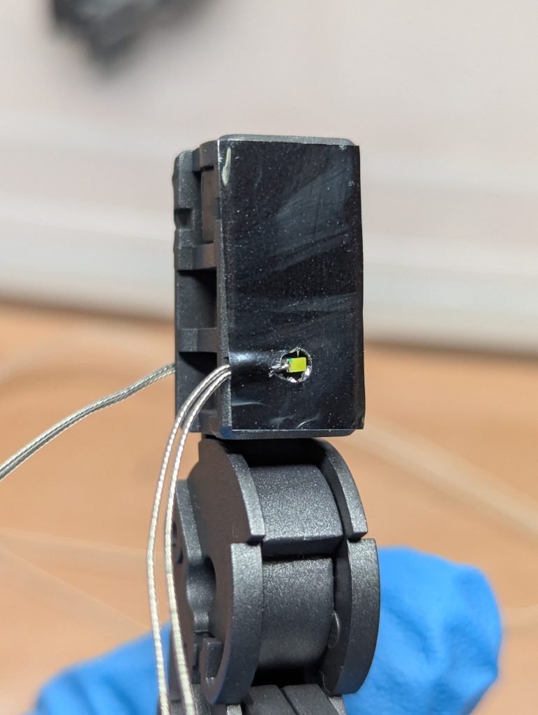 二の腕のLED追加箇所。軽く穴を空けてLED埋込、配線はパーツに少し溝を掘って通し、ラピーテープでついでに固定。