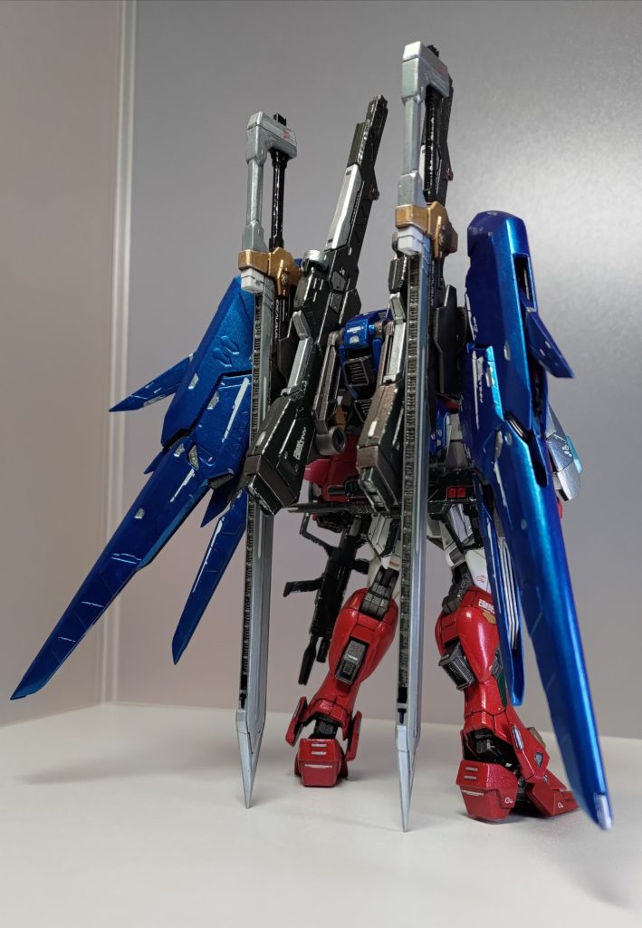 バックショットです。ビームライフルが左手とリアスカートで2丁あるんですけど、手に持ってるのは以前リビルドしましたジャンク品の旧HGデスティニーを買ったときに同梱されていた、旧HGインパルスのものです。せっかくなんで予備として持たせちゃいました。