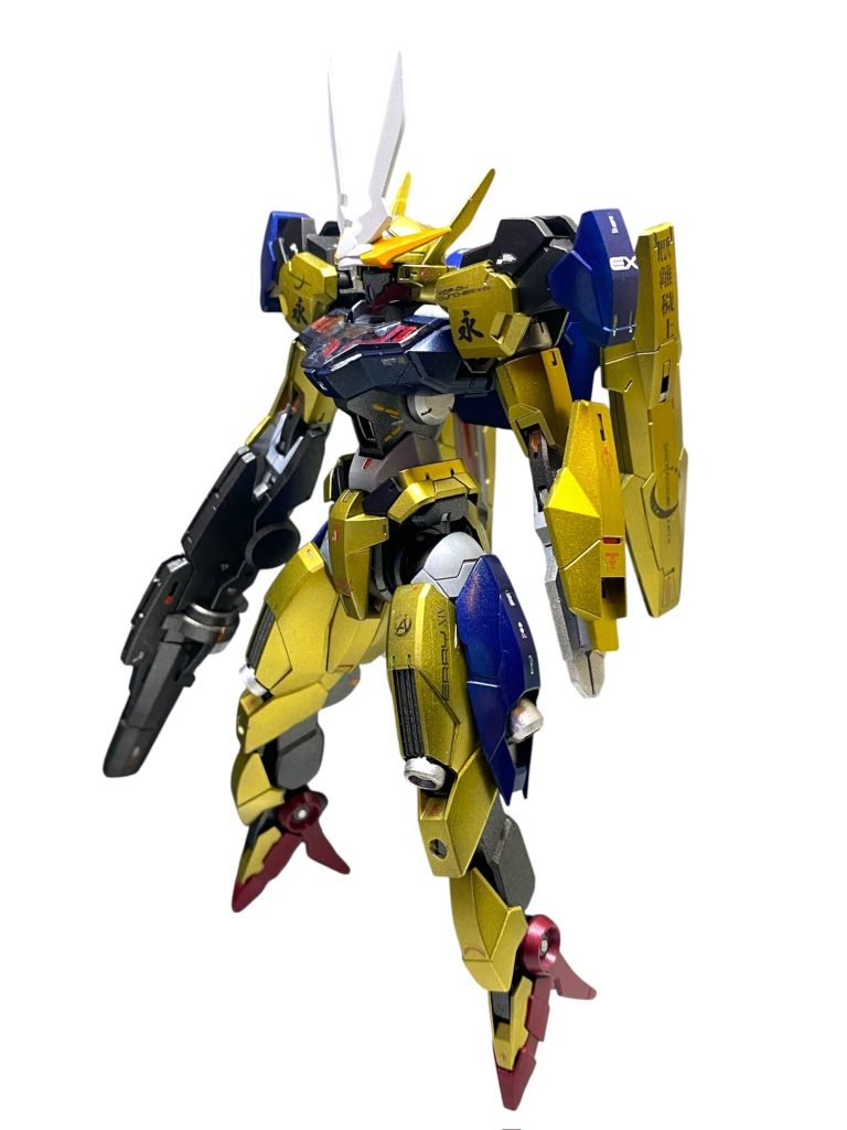 【あとがき】みなさん、本当にお久しぶりです!!前回の公開からはや一か月、、、前作は昨年中には完成していましたから、実質的にはコレが2026年に入って最初に完成した作品となります笑2週間に一作のペース?隔週連載?は??締切は伸びに伸び、もはや月刊連載のペースですが、何とか完成させました第5章❗️言い訳ですが、キットがゴテゴテとデカかったから、年明けからずっと仕事に追われてたから…色々ありますが、出来上がったものが全てです!という事で、ベースとなるこちらはガンドノードをベースとしたミキシングですが、ほぼほぼイジってません。組み替えてカラーリングを派手に変更しただけ、とでも言いましょうか☺️派手です✨金です✨カラーリング、ロービジとか色々迷いましたが、百式をオマージュした金としました❗️(最近、冬季五輪で金メダルとか色々あったしね🎖️)意外なほどマッチしてます!肩部の漢字も“百”をイメージして、永遠の命を実現する為の尖兵である事と、百式のデザイナーの永野護先生をリスペクトして“永”としました。金ピカの鎧「金陀美具足」からのインスピレーションで、家康公の旗印“厭離穢土 欣求浄土”の文字もデカールで作ってみました。今回は金色にもこだわりたかったので、いつもよりも奮発して水性ホビーカラーの「スーパーファインゴールド」を使いました✨非常にきめ細やかな黄金色です。
