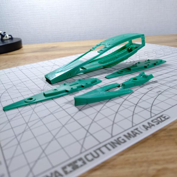 ジワジワと進めているマゼラン、昨年末からいよいよ船体に着手しました。しかし‼️進める中で色々な問題が出てきて頭が煮詰まってしまいました😅このまま進むとロクな事にならない気がしましたので、一旦マゼランからは離れ、気分転換をしようと思います。でもせっかくなので、ここまでやって来た事は、以下に記そうかと。よろしければご覧下さいませ。さて、武装の大増設を実現するには船体をかなり拡張しなければならず、とはいえその方法が全くイメージ出来ない為、船体を切り刻んでマゼランらしい意匠を持つ各所パーツを形成しつつ、船体自体の形成については『ひらめきを待つ😅』という、場当たり的な進め方を採用しました😁でもねぇ…マゼランらしい各所意匠は使いたいものの、船体の形自体はこの上なく厄介なんですよね。とても流麗で美しく、それでいて全く発展性の余地がないフォルム🥲タテヨコ共に大幅拡張が必要なのに、発展性がないのは致命的で、頭を抱える日々が続きました。数mm延長とかでは意味がないし。悩んだ結果、船体そのものは元パーツを使わずプラ板でフルスクラッチし、各所意匠は切り出して加工、フルスクラッチした船体に乗せる(貼る)という決断をしました。幸いパーツは複数あるので、失敗もコワくありません😁【写真②】パーツを切り出す為に『三枚おろし』になった船体です。【写真③】船体後部の尾翼(？)部分を上下に配してORIGINに寄せてみました。【写真④】切り出した意匠をエポパテで肉付けしたところです。四連装砲塔の台座です。【写真⑤】船首部分も貧弱だったので、上下に2つ張り合わせて肉厚にしました。先端は避弾経始も良好です。ドメラーズⅢみたい😊【写真⑥】加工した各意匠パーツに、サフを吹いたところです。【写真⑦】各パーツをあるべき場所に配し、主砲を乗せてみました。感じ出てきました🤤さぁ‼️あとは船体作ってパーツ貼り付けだ‼️と思った頃に、色々問題が発覚しました。・主砲の台座を削り過ぎ、高さが足りなくなってしまった🥲・何と、主砲塔をはめ込む穴が中心からあちこちズレている。さすがは旧キット。艦船模型って、正面から見た時のシンメトリー(左右対称)が大きな見どころであり、これを全て手作業でキレイに修正するのはかなりホネである🥲・自作したエンジン部分、造形にラッカーパテを使ったところ、気泡だらけになり、しかも全く埋まらず、打ち出しコンクリートの表面みたいになっている🥲時間をかけて作ったモノをまたやり直したり、主砲塔の穴が中心からズレているという、艦船模型にあってはならない欠陥が見つかったり、心がキレイにポッキリ折れました🥲『いっそ3Dプリンタでも買うたろかぁ⁉️』と身も蓋もない選択肢まで頭を巡り、少し頭を冷やす必要を感じました。すると他にやりたい事も頭に浮かび、『こりゃあ、気分転換した方が良いな😁』となりましたので、マゼランからは一旦離れてジオニストに戻ろうと思います。しばらく置けば、意欲もアイディアもまた湧き出す事でしょう(ホントかなぁ😁)。再開したら、また良ければ見てやって下さいませ。長文お付き合い、ありがとうございます🙇そしてマゼラン君、その日までしばしお休み😊（2枚目）