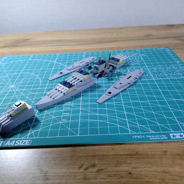 ジワジワと進めているマゼラン、昨年末からいよいよ船体に着手しました。しかし‼️進める中で色々な問題が出てきて頭が煮詰まってしまいました😅このまま進むとロクな事にならない気がしましたので、一旦マゼランからは離れ、気分転換をしようと思います。でもせっかくなので、ここまでやって来た事は、以下に記そうかと。よろしければご覧下さいませ。さて、武装の大増設を実現するには船体をかなり拡張しなければならず、とはいえその方法が全くイメージ出来ない為、船体を切り刻んでマゼランらしい意匠を持つ各所パーツを形成しつつ、船体自体の形成については『ひらめきを待つ😅』という、場当たり的な進め方を採用しました😁でもねぇ…マゼランらしい各所意匠は使いたいものの、船体の形自体はこの上なく厄介なんですよね。とても流麗で美しく、それでいて全く発展性の余地がないフォルム🥲タテヨコ共に大幅拡張が必要なのに、発展性がないのは致命的で、頭を抱える日々が続きました。数mm延長とかでは意味がないし。悩んだ結果、船体そのものは元パーツを使わずプラ板でフルスクラッチし、各所意匠は切り出して加工、フルスクラッチした船体に乗せる(貼る)という決断をしました。幸いパーツは複数あるので、失敗もコワくありません😁【写真②】パーツを切り出す為に『三枚おろし』になった船体です。【写真③】船体後部の尾翼(？)部分を上下に配してORIGINに寄せてみました。【写真④】切り出した意匠をエポパテで肉付けしたところです。四連装砲塔の台座です。【写真⑤】船首部分も貧弱だったので、上下に2つ張り合わせて肉厚にしました。先端は避弾経始も良好です。ドメラーズⅢみたい😊【写真⑥】加工した各意匠パーツに、サフを吹いたところです。【写真⑦】各パーツをあるべき場所に配し、主砲を乗せてみました。感じ出てきました🤤さぁ‼️あとは船体作ってパーツ貼り付けだ‼️と思った頃に、色々問題が発覚しました。・主砲の台座を削り過ぎ、高さが足りなくなってしまった🥲・何と、主砲塔をはめ込む穴が中心からあちこちズレている。さすがは旧キット。艦船模型って、正面から見た時のシンメトリー(左右対称)が大きな見どころであり、これを全て手作業でキレイに修正するのはかなりホネである🥲・自作したエンジン部分、造形にラッカーパテを使ったところ、気泡だらけになり、しかも全く埋まらず、打ち出しコンクリートの表面みたいになっている🥲時間をかけて作ったモノをまたやり直したり、主砲塔の穴が中心からズレているという、艦船模型にあってはならない欠陥が見つかったり、心がキレイにポッキリ折れました🥲『いっそ3Dプリンタでも買うたろかぁ⁉️』と身も蓋もない選択肢まで頭を巡り、少し頭を冷やす必要を感じました。すると他にやりたい事も頭に浮かび、『こりゃあ、気分転換した方が良いな😁』となりましたので、マゼランからは一旦離れてジオニストに戻ろうと思います。しばらく置けば、意欲もアイディアもまた湧き出す事でしょう(ホントかなぁ😁)。再開したら、また良ければ見てやって下さいませ。長文お付き合い、ありがとうございます🙇そしてマゼラン君、その日までしばしお休み😊（7枚目）