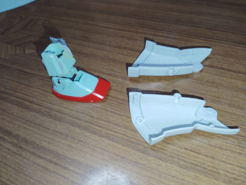 　脚部の加工です。　HGUCジムのスネを適当な長さで切断し、その上からMSVジムキャノンのパーツを被せていきます。　そのままでは当然幅がスカスカなので、余った部品やジャンクパーツをパテで張り付けて幅増しし、固定しました。　後頭部やキャノン砲の移植に比べれば、ここは意外とすんなり形になってくれました。