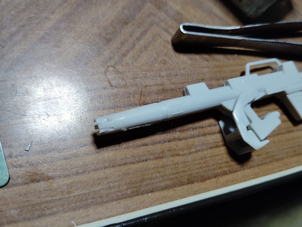 　キャノン砲先端部分の加工です。　ジムキャノンのキャノン砲先端は、媒体によって切り欠きがあったりなかったりします。　旧キットMSVのジムキャノンには切り欠きがありましたが、「戦場の絆」に登場する本機のキャノン砲には切り欠きがなくシンプルな形状だったので、細切りにしたプラ板とパテで埋めてしまいました（画像はまだプラ板の細切りのみで埋めた状態です）。