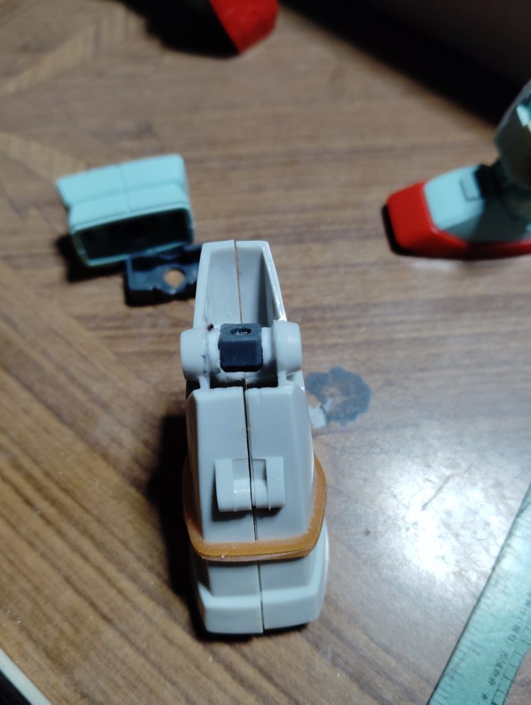 　ヒザ関節です。　HGUCジムの太ももと接続するポリキャップを仕込むため、穴を開けたプラ板をなるべく小さな円になるように削り、ジムキャノンのヒザ関節（もともとあった円柱状の関節はカッターノコとヤスリで切除しました）に貼り付けました。　ポリキャップも挟んで位置を固定したら輪ゴムで縛り、数日乾燥させて完成です。　なんとかうまくジムの太ももと接続し、可動範囲を確保することができました。