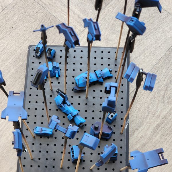 モデルはまだ完成していませんが、我慢できずにちょっとだけお見せするために組み立ててみることにしました。長々と話さないようにします。このモデルの塗装で多くのことを学びました。小さな決断が、結果を大きく左右するのです。最初の頃は気に入らなかったのですが、今は納得し始めています。さあ、早速見ていきましょう。表面は、スプレー缶のブラックのアーミーペインタープライマーです。この製作にはヴァレホの塗料を使用しています。一番濃い青から始めて、明るい青へとグラデーションを作っていきます。今回は頭部にもっと注意を払いたいと思いました。グスタフ・カールの頭部は少し雑でした。スポンジを空けてドライブラシ風のアプローチをすると、頭部の盛り上がった部分を捉えて光に当てることができ、うまくいきました。全体的にとても青くなっています。もしかしたら青すぎるかもしれません。幸い、赤が少しだけバランスを取ってくれています。次回は、鎧と手足を区別するために別の色を加えてみたいと思っています。武器はまだ少し作業が残っているので、一緒に飾るためのカスタムベースをもう一つ作ってみたいと思っています。読んでいただきありがとうございました。またのご来店をお待ちしております。-The model is not finished but I could not resist and decided to build it up for a quick sneak peek.I'll try not to ramble on.I learned a lot painting this model. So many small decisions make for a vastly different outcome. After disliking it in the early stages I've started to come round on now. Let's dive in and have a look.The surface layer is black Army Painter primer from a spray can.I use Vallejo paints for this build. Starting with the darkest blue, I create a gradient into light blues.This time I wanted to pay closer attention to the head. The Gustav Karl head was a little sloppy.I found that unloading the sponge and doing a dry brush style approach worked well on the head piece, to catch the raised areas and bring them into the light.Overall, it is very blue. Maybe too blue. Luckily the red helps to break it up a little. Next time I would like to try to add another colour to separate the armour from the limbs.I still have some work to do on the weapons and want to try and create another custom base to display it with.Thank you for reading and please stay tuned. (3枚目)