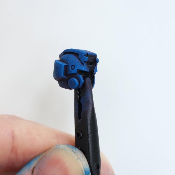 モデルはまだ完成していませんが、我慢できずにちょっとだけお見せするために組み立ててみることにしました。長々と話さないようにします。このモデルの塗装で多くのことを学びました。小さな決断が、結果を大きく左右するのです。最初の頃は気に入らなかったのですが、今は納得し始めています。さあ、早速見ていきましょう。表面は、スプレー缶のブラックのアーミーペインタープライマーです。この製作にはヴァレホの塗料を使用しています。一番濃い青から始めて、明るい青へとグラデーションを作っていきます。今回は頭部にもっと注意を払いたいと思いました。グスタフ・カールの頭部は少し雑でした。スポンジを空けてドライブラシ風のアプローチをすると、頭部の盛り上がった部分を捉えて光に当てることができ、うまくいきました。全体的にとても青くなっています。もしかしたら青すぎるかもしれません。幸い、赤が少しだけバランスを取ってくれています。次回は、鎧と手足を区別するために別の色を加えてみたいと思っています。武器はまだ少し作業が残っているので、一緒に飾るためのカスタムベースをもう一つ作ってみたいと思っています。読んでいただきありがとうございました。またのご来店をお待ちしております。-The model is not finished but I could not resist and decided to build it up for a quick sneak peek.I'll try not to ramble on.I learned a lot painting this model. So many small decisions make for a vastly different outcome. After disliking it in the early stages I've started to come round on now. Let's dive in and have a look.The surface layer is black Army Painter primer from a spray can.I use Vallejo paints for this build. Starting with the darkest blue, I create a gradient into light blues.This time I wanted to pay closer attention to the head. The Gustav Karl head was a little sloppy.I found that unloading the sponge and doing a dry brush style approach worked well on the head piece, to catch the raised areas and bring them into the light.Overall, it is very blue. Maybe too blue. Luckily the red helps to break it up a little. Next time I would like to try to add another colour to separate the armour from the limbs.I still have some work to do on the weapons and want to try and create another custom base to display it with.Thank you for reading and please stay tuned. (4枚目)