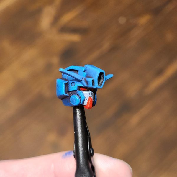 モデルはまだ完成していませんが、我慢できずにちょっとだけお見せするために組み立ててみることにしました。長々と話さないようにします。このモデルの塗装で多くのことを学びました。小さな決断が、結果を大きく左右するのです。最初の頃は気に入らなかったのですが、今は納得し始めています。さあ、早速見ていきましょう。表面は、スプレー缶のブラックのアーミーペインタープライマーです。この製作にはヴァレホの塗料を使用しています。一番濃い青から始めて、明るい青へとグラデーションを作っていきます。今回は頭部にもっと注意を払いたいと思いました。グスタフ・カールの頭部は少し雑でした。スポンジを空けてドライブラシ風のアプローチをすると、頭部の盛り上がった部分を捉えて光に当てることができ、うまくいきました。全体的にとても青くなっています。もしかしたら青すぎるかもしれません。幸い、赤が少しだけバランスを取ってくれています。次回は、鎧と手足を区別するために別の色を加えてみたいと思っています。武器はまだ少し作業が残っているので、一緒に飾るためのカスタムベースをもう一つ作ってみたいと思っています。読んでいただきありがとうございました。またのご来店をお待ちしております。-The model is not finished but I could not resist and decided to build it up for a quick sneak peek.I'll try not to ramble on.I learned a lot painting this model. So many small decisions make for a vastly different outcome. After disliking it in the early stages I've started to come round on now. Let's dive in and have a look.The surface layer is black Army Painter primer from a spray can.I use Vallejo paints for this build. Starting with the darkest blue, I create a gradient into light blues.This time I wanted to pay closer attention to the head. The Gustav Karl head was a little sloppy.I found that unloading the sponge and doing a dry brush style approach worked well on the head piece, to catch the raised areas and bring them into the light.Overall, it is very blue. Maybe too blue. Luckily the red helps to break it up a little. Next time I would like to try to add another colour to separate the armour from the limbs.I still have some work to do on the weapons and want to try and create another custom base to display it with.Thank you for reading and please stay tuned. (5枚目)