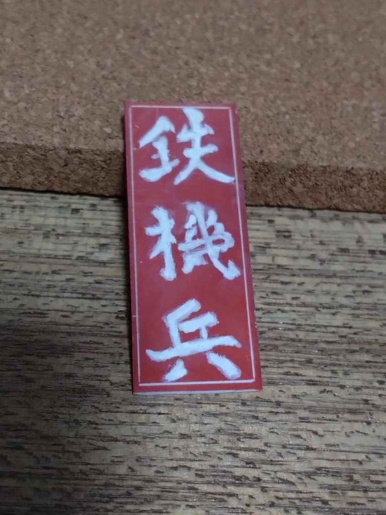 コレもそれっぽくオキサイドレッドに白で書いてます。縁の白はスジボリしました。裏にテープで色々な所に貼れる様にしてます。