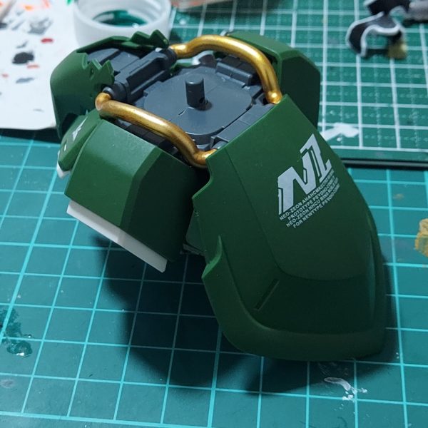 腰のパーツが完成しました。写真を撮って見ると真ん中のバリ跡が目立ちますね…紙やすりとかで処理したつもりだったけどまだまだのようです。ここもデカールで隠すしかないか?またイエローゴールドが剝がれやすく、ガンダムマーカーのクリアー光沢で保護したはずなのにパーツをはめようとするとすぐ剥がれてしまうので、3回くらい塗りなおしました。最後は水性トップコートで保護。実はこれからあるギミックを仕込むのですが、そのためのパーツが日曜までに届かなかったので、この週末では完成しませんでした。というか、グレービングの塗装が終わっていないのを忘れていました。こちらもトライアンドエラーの繰り返しですが、少しずつ完成に近づいています。また、バインダーの支持アームにディテールを追加。バックパックと同じウェーブのU・バーニア【角】Mを使用しています。なんとか3月中には完成させたいなぁ。(2枚目)