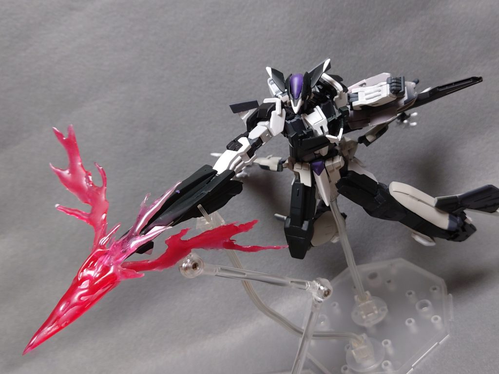 ・試製位相空間複合制御兵装システム〝イヅシノホコ〟シールド(MA時の機首にあたる部位)を分離して使用する大型実体槍。推進システムであるJ.S.Jを近接兵装として転用、触れる事をトリガーとして、対象の位相的安定性に干渉、装甲条件を無視して直接的なダメージを与える。本兵装に切断能力は無いが、位相空間制御により対象を削り取るような攻撃が可能。リミッターを解除し、触れるという条件を無視しての使用も可能となっており、高度な空間把握能力が必要だが、動かずとも対象を破壊する事ができる。───開発を行ったのは匿名の機関であるが、MS用の武装の制作経験が無かったため四苦八苦したとのこと。