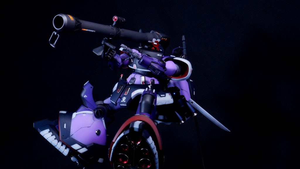 ちらっとしか見えていませんが、脚の裏のバーニアも内部を赤く塗り分けています。ソリッドの赤を塗ったことはこれまでもありましたが、今回はクリアーレッドでキャンディ塗装のようにしています。また、今回、今までと塗装の仕方を変えた部分としては、メタリック塗装する部分の下地をちゃんと光沢ブラックにしています。これまでは黒サフで全部塗ってしまっていたので、メタリックはきれいに艶が出ていませんでした。前回ハロをテカテカの光沢に仕上げたことで、光沢塗装、メタリック塗装をちゃんと艶や光沢が出るようにしよう！という考えが生まれたからです。(gundam-kao2)写真でわかるか微妙ですが、これまでより、メタリック部分の輝きがいい感じになった、つもりです。(zaku-kao10)