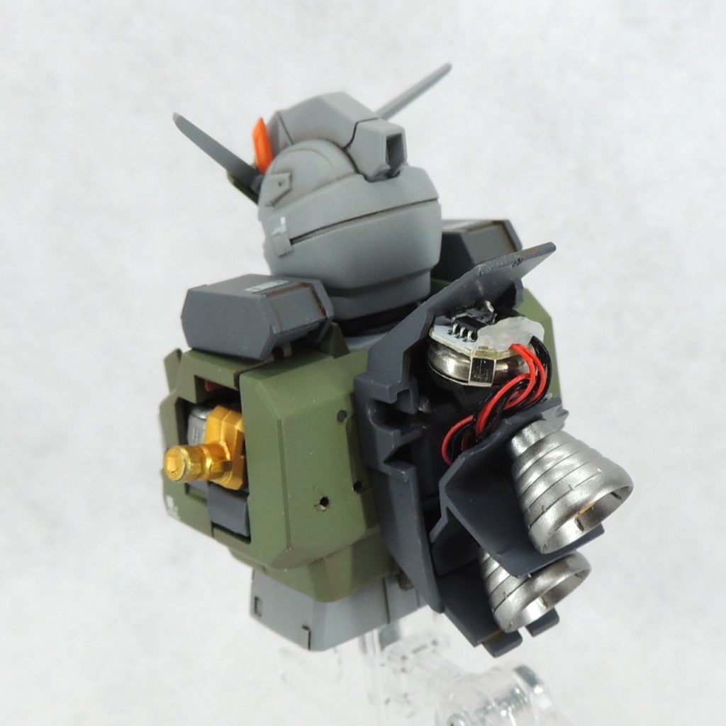 ■電飾　頭頂部のメインカメラ及びツインアイに電飾を仕込みました。使用した商品は、「W-PARTS LEDモジュール （磁気スイッチ付） リードタイプ 緑 [プラモデル用パーツ]」であり、３か所を同時で光らせることができます。磁石をボタン電池ボックスに近づけることにより、簡単にオン・オフの操作をおこなうことができ、点灯パターンは「①点灯→②高速点滅→③ゆっくりとした点滅→④消灯」の順に切り替わります。ボタン電池(CR927／3v)ボックス兼スイッチはバックパック内部上面に設置しました。