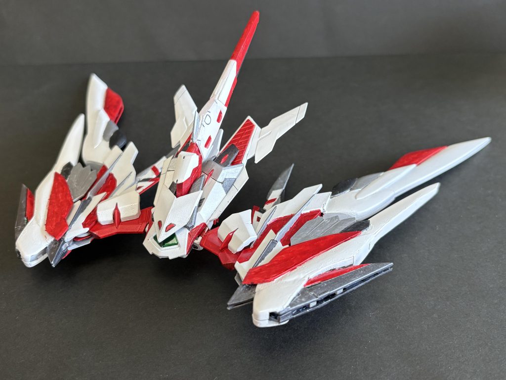 そもそもロードを改造する時点でアマテラスみたいなやつを作りたいなと思ってたんですよ。そしてSEEDFREEDOM見た後で、プラウドディフェンダーっぽい強化用支援機欲しいなあって思って、二つを融合させたモノとして作りました。ベースはRGゴールドフレーム天のバックパック、マガノイクタチの代わりにRGウイングゼロEWの翼を2枚づつ装備、尾翼はRGデスティニーから拝借。マガノシラホコはナイフ状に改造し、後はあれこれジャンクを貼り付けてでき上がったものがこちらになります。