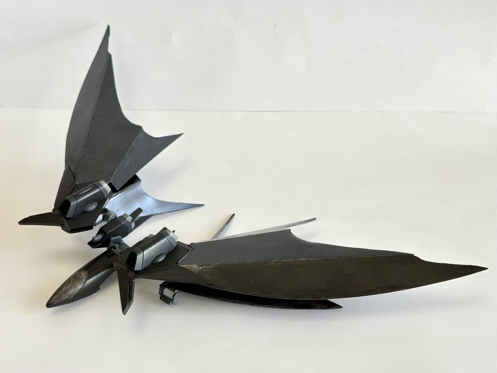 QCiC-Fe-19　クーストース　“監視者”。イモータルジャスティスのリフターを改造したフライトユニット。大気圏内での飛行や宇宙での機動力増強を目的とした追加装備。特に飛膜状のウイング部は、ガンダニュウム合金にABCマントを積層＆蒸着させた優れた防御力を誇る頑強な翼となっている…………みたいな設定です。　本体改造したときに余ったリフターをなんとか使いたいと思った末に、デスサイズみたいなメカコウモリウイング欲しいと思ったので作りました。飛膜はプラ板でスクラッチし、あとは細かい部分をいじってそれっぽい形にしています。ジャスティスらしさはしっかりどっかに棄てられたと思います。