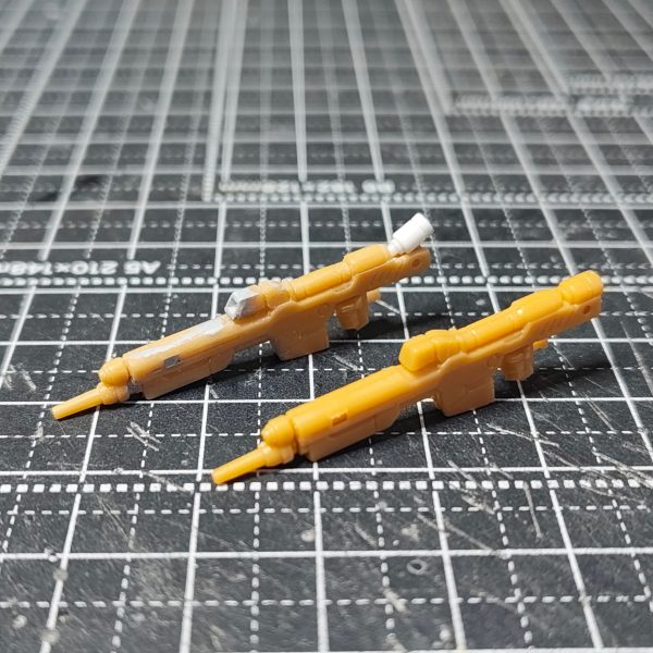 【ガンダムアーティファクト　Hi-νガンダム　ライフル　シールド改修】①ビームライフルのセンサー部分と後方部のディテール追加。②シールドのダクト部分のディテール変更。切り抜いて、プラ板でモールドを掘ったものをはめ込む。裏も接続部分をネオジムを仕込む。③シールドアタッチメントの制作。直径2㎜厚さ1㎜のネオジムをＬ字型にプラ板、プラ棒で制作したアタッチメントの2面に仕込む。④アタッチメントの2面を使い、肘を曲げても横の面に装着できます。⑤腕にもネオジムを仕込んでいるので、シールド装備しないときのネオジム隠しを制作。フタにネオジム仕込んでます。大きな変更はしていませんが情報量をちょい足し改修でした。アタッチメントは、前回の改修ではホチキスの針で磁石受けをしていましたが取れやすかったのでネオジムをふんだんに使いました。（2枚目）