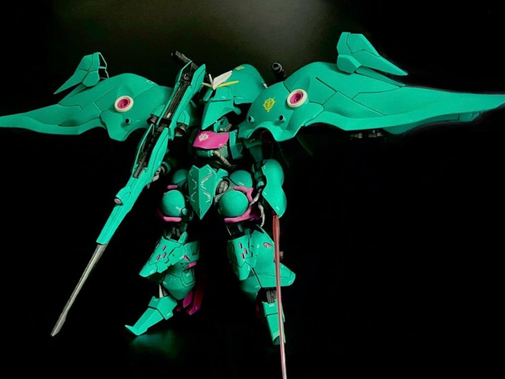 最後に精密狙撃用にロングレンジテールライフルビットを携えて前作シャロンの薔薇は元々SEED世界線のカオスガンダムがコアユニットであった為まさに世界線が混沌としていた状況をスッキリさせるべく同じ宇宙世紀世界線のMSに置き換えるという企画たまたまGQザクが入手できた (前記事)のだが、中のMSをそのままザクに入れ替えるだけではつまらない、と一捻り加える際に「同じエルメスカラー」で人気のキュベレイ (パピヨン)をモチーフにそれらしいシルエットになるようにジャンクパーツを駆使してミキシングこれでザク-エルメス-キュベレイと繋がる「宇宙世紀に革命を起こした」エポックメイキングを体現する一体になりスッキリ尚、頭部カバーについては試行錯誤した結果キュベレイデザイナーの永野護氏繋がりでFSSのモーターヘッド風の「とんがり帽子の下の小さなマスク」っぽいフェイス案が生まれて「これはこれで好みなのでアリ」ということで完成に至った