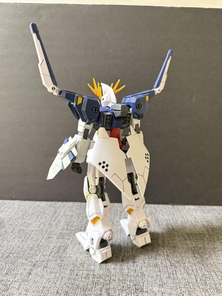 【開発経緯①】U.C.0090年代後半、地球連邦軍は長期化の様相を見せ始めた シャアの反乱 を受け、ニュータイプ勢力による武装蜂起や大規模反乱への対抗戦力として新たなガンダム開発計画を立案した。この計画は 「第二次ガンダム開発計画」、通称 セカンドGP計画 と呼ばれ、かつてのガンダム開発計画の流れを汲む極秘プロジェクトとして進められた。計画の開発管理総責任者には、かつて試作ガンダム計画に関わった技術者 ニナ・ウラキ が就任している。セカンドGP計画では、将来的なニュータイプ専用兵器や高機動戦闘に対応するための第5世代モビルスーツの試作シリーズとして オデュッセウス級モビルスーツ が開発された。このシリーズはモジュール換装を前提としたコアユニット方式を採用しており、任務に応じた外装ユニットを装着することで多様な戦闘環境に対応する設計思想を特徴としていた。その2号機として開発されたのが アルケイデスガンダム である。本機は宇宙空間での戦闘を主眼に置いて設計された機体であり、遠隔兵装を主体としたオールレンジ戦闘能力の強化を目的としていた。特に専用装備である フィックス・アルゴスユニット の運用を前提としたコア機体として調整されており、多数の遠隔誘導兵装を統合的に制御するサイコミュシステムを中核に据えた構成となっている。