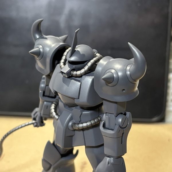 やっとこさサフを吹きました。ガイアのメカサフヘヴィを使ってますが、蛇腹パイプやヒートロッド、バックパックはサフ代わりに焼鉄色を吹いてます。上塗は本体と同じ青系を塗るつもりですが、下地の色を変えることで異素材感が出てくれるかどうかの実験です。焼鉄色を初めてエアブラシで塗ってみたんですが、筆塗りとは粒子のギラつき具合が全然違いますね。初めてこの色のポテンシャルをフルに発揮できた思いです。あと失敗箇所ですが、サフ前に先だってヒートサーベルを塗ってたんです。そんで今度は刀身部分をマスキングして柄の方にサフ吹いたんですが、刀身を百均の塗装棒で挟んでたらマステ貫通して塗装に穴空きました(zaku-kao9) 意外と凶暴でしたね。悲しみを超えて立てよ国民!ここから楽しい筆塗りのターンだ!(1枚目)