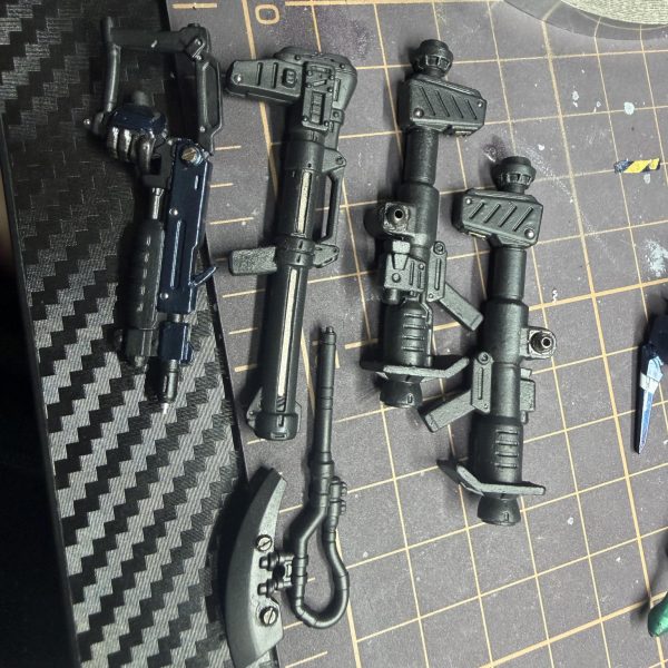 今日は一個前のコンバージのケンプファー武器が余っていたので武装改造してみました。&nbsp;そのままだと持つ所が無かったので持ち手を自作。斧も付いていたのですが手から離れない構造だったので一度切断して金属パーツに変更。&nbsp;バズーカは金属板を薄く切って差し込み、さらにメタルボールを入れまくってディテールアップ。&nbsp;現行ケンプファーのバズーカの一部には鉛シールを貼って、その上からクリアブラックを塗装。金属そのまま感が少し嫌だったのでトーンを落としてみました。&nbsp;この鉛シール、色々使えてかなりおすすめです。&nbsp;斧と「これは何だろう…地雷棒？」みたいな武器も磁石で脱着できるように改造。地雷棒にも鉛シール入れてます。&nbsp;接着剤があまり得意じゃないので基本は&nbsp;塗装汚れる → ヤスリ → 再塗装&nbsp;みたいな感じで作ってます。&nbsp;斧の刃先はもっと本物の刃っぽい色にしたいので、そこはまだ改良予定。&nbsp;そして当初からやりたかったバズーカにケーブル追加。&nbsp;実際バズーカにケーブル付いてるのかは正直分からないんですが…&nbsp;出来るだけ意味不明な改造はしたくないので&nbsp;「バズーカにケーブルは普通付かないよ」&nbsp;とかあればぜひ教えて下さい。勉強になります。&nbsp;あとこの武器なんでしょう？名前分かる方いたら教えてください。&nbsp;今はまだサーフブラック状態なので黒色を微調整して&nbsp;LED仕込みバーニア追加&nbsp;やろうかなと思ってます。&nbsp;コメントなくて少し寂しいですがシコシコ頑張ります🥹（6枚目）