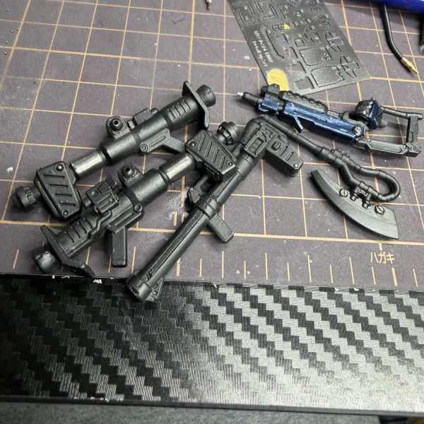 今日は一個前のコンバージのケンプファー武器が余っていたので武装改造してみました。&nbsp;そのままだと持つ所が無かったので持ち手を自作。斧も付いていたのですが手から離れない構造だったので一度切断して金属パーツに変更。&nbsp;バズーカは金属板を薄く切って差し込み、さらにメタルボールを入れまくってディテールアップ。&nbsp;現行ケンプファーのバズーカの一部には鉛シールを貼って、その上からクリアブラックを塗装。金属そのまま感が少し嫌だったのでトーンを落としてみました。&nbsp;この鉛シール、色々使えてかなりおすすめです。&nbsp;斧と「これは何だろう…地雷棒？」みたいな武器も磁石で脱着できるように改造。地雷棒にも鉛シール入れてます。&nbsp;接着剤があまり得意じゃないので基本は&nbsp;塗装汚れる → ヤスリ → 再塗装&nbsp;みたいな感じで作ってます。&nbsp;斧の刃先はもっと本物の刃っぽい色にしたいので、そこはまだ改良予定。&nbsp;そして当初からやりたかったバズーカにケーブル追加。&nbsp;実際バズーカにケーブル付いてるのかは正直分からないんですが…&nbsp;出来るだけ意味不明な改造はしたくないので&nbsp;「バズーカにケーブルは普通付かないよ」&nbsp;とかあればぜひ教えて下さい。勉強になります。&nbsp;あとこの武器なんでしょう？名前分かる方いたら教えてください。&nbsp;今はまだサーフブラック状態なので黒色を微調整して&nbsp;LED仕込みバーニア追加&nbsp;やろうかなと思ってます。&nbsp;コメントなくて少し寂しいですがシコシコ頑張ります🥹（3枚目）