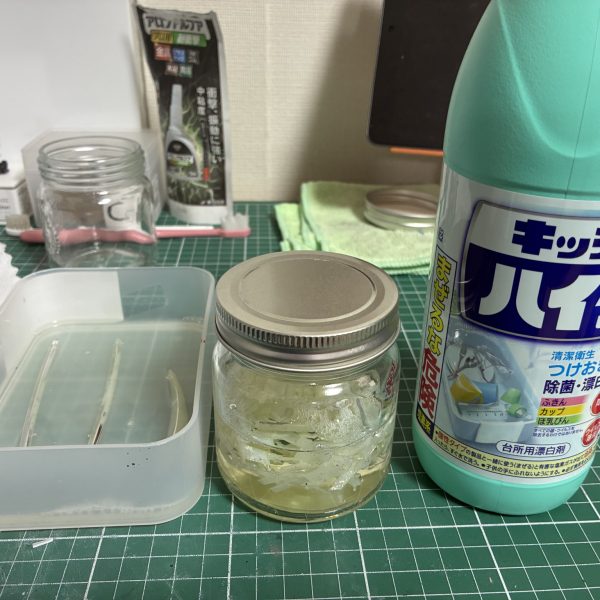 はじめてのメッキ剥がし【用意したもの】・クレオスうすめ液・蓋つき瓶 100円×2・ドリッパーのフィルター・キッチンハイター(塩素系)調べても工程を些細に記載したものがなかなか見つからないのでまとめました以下、工程【写真2〜4枚目】・ゴールド部分を剥がす作業・メッキではなくクリアイエローを剥がす作業なので、ランナーから落としたパーツを瓶に入れてシンナー風呂・漬けた瞬間から液剤は黄土色に染まるぐらいにはスピーディーに色が抜けていく・蓋つき瓶にした事で寝かして振ったりが可能だったのでムラなく色を落とすことが出来た・5分もかからずゴールドは無くなる・濾過作業は5回ほどに分けて少しずつ。紙フィルターは片付けも含めて慎重になる必要がなく正解でした【写真5〜7枚目】・本題のメッキ剥がし・ハイターにも色々と○○系というような種類があるようで、実例で見かけるキッチンハイター(塩素系)を用意した・長物は平らなトレーに…しましたがゴールドと同じく瓶に突っ込んで振った方が早かった・漬けて2分ほどで小さいパーツはメッキが溶けて下地の乳白色に・瓶を寝かして転がしたりでこちらも5分とかからず全てのパーツが下地の乳白色に・失敗したなと思ったのはハイターは泡立つので振りすぎ注意。泡で取り出しにくくなる上に今回のように乳白色のパーツは取り忘れがないか見分けにくい。正しく「漬ける」でいいと思った 【やってみての感想】・想像以上に時間がかからない。洗う時間のほうが長い・突貫なら総作業を30分ぐらいでやれそう・メッキごとに特長もあるようなので、今回はガンプラメッキの場合の結果でおさめようと思う【良かった点】・濾過用にフィルターともう一つ瓶を用意したこと・蓋つきの瓶【反省点、困った点】・ハイターを泡立たせた・プラモだけの用事にしてはハイターのボトルがデカい・洗い物が多い以上です。何かの参考になれば(5枚目)