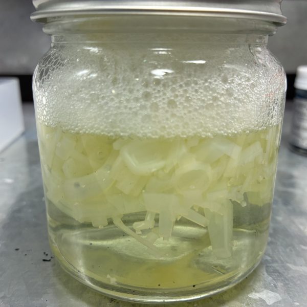 はじめてのメッキ剥がし【用意したもの】・クレオスうすめ液・蓋つき瓶 100円×2・ドリッパーのフィルター・キッチンハイター(塩素系)調べても工程を些細に記載したものがなかなか見つからないのでまとめました以下、工程【写真2〜4枚目】・ゴールド部分を剥がす作業・メッキではなくクリアイエローを剥がす作業なので、ランナーから落としたパーツを瓶に入れてシンナー風呂・漬けた瞬間から液剤は黄土色に染まるぐらいにはスピーディーに色が抜けていく・蓋つき瓶にした事で寝かして振ったりが可能だったのでムラなく色を落とすことが出来た・5分もかからずゴールドは無くなる・濾過作業は5回ほどに分けて少しずつ。紙フィルターは片付けも含めて慎重になる必要がなく正解でした【写真5〜7枚目】・本題のメッキ剥がし・ハイターにも色々と○○系というような種類があるようで、実例で見かけるキッチンハイター(塩素系)を用意した・長物は平らなトレーに…しましたがゴールドと同じく瓶に突っ込んで振った方が早かった・漬けて2分ほどで小さいパーツはメッキが溶けて下地の乳白色に・瓶を寝かして転がしたりでこちらも5分とかからず全てのパーツが下地の乳白色に・失敗したなと思ったのはハイターは泡立つので振りすぎ注意。泡で取り出しにくくなる上に今回のように乳白色のパーツは取り忘れがないか見分けにくい。正しく「漬ける」でいいと思った 【やってみての感想】・想像以上に時間がかからない。洗う時間のほうが長い・突貫なら総作業を30分ぐらいでやれそう・メッキごとに特長もあるようなので、今回はガンプラメッキの場合の結果でおさめようと思う【良かった点】・濾過用にフィルターともう一つ瓶を用意したこと・蓋つきの瓶【反省点、困った点】・ハイターを泡立たせた・プラモだけの用事にしてはハイターのボトルがデカい・洗い物が多い以上です。何かの参考になれば(6枚目)